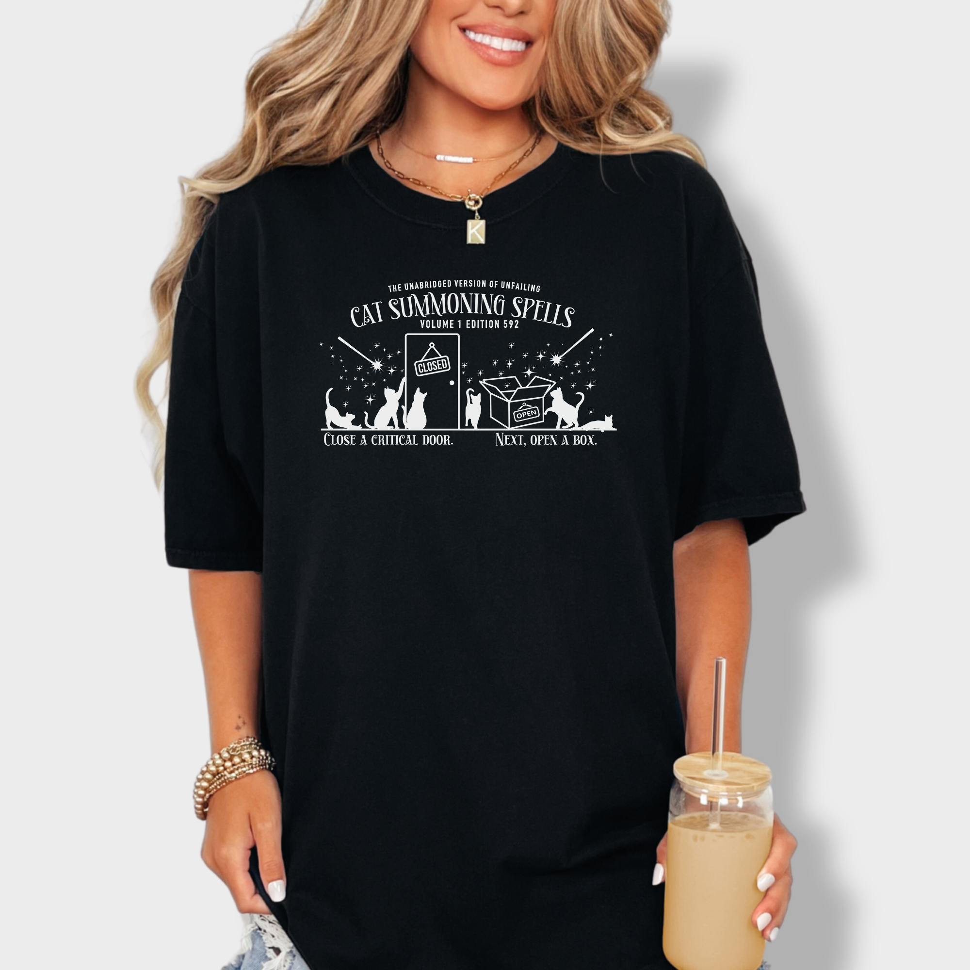 Funny cat magic T-shirt with a simple one-color book design, illustrating spells that summon cats to doors and open boxes.
