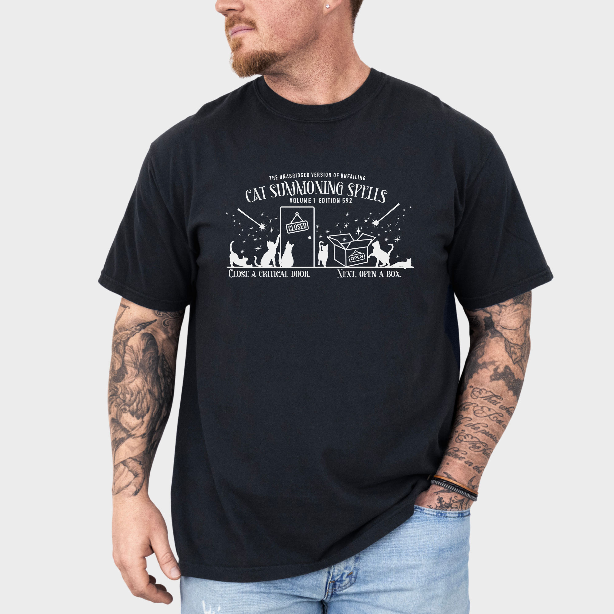 Whimsical minimalist cat lover's T-shirt featuring a spellbook titled 'Cat Summoning Spells' and magical wands attracting cats.