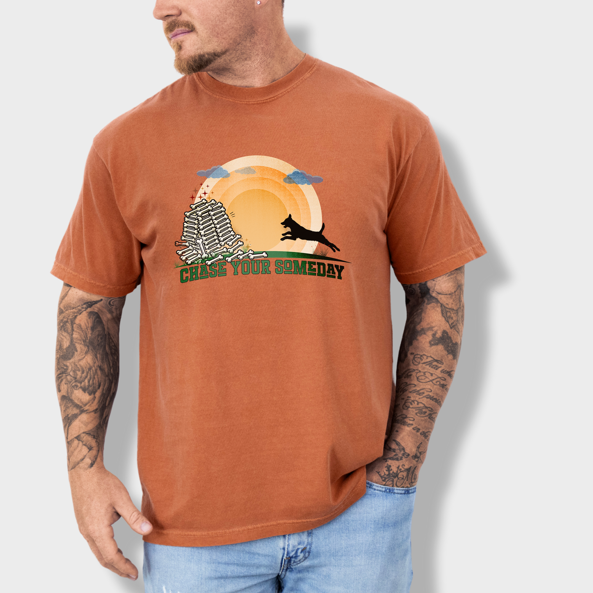 Soft cotton T-shirt featuring a dynamic dog sprinting toward a dream-like pile of bones, with bold college-style text.