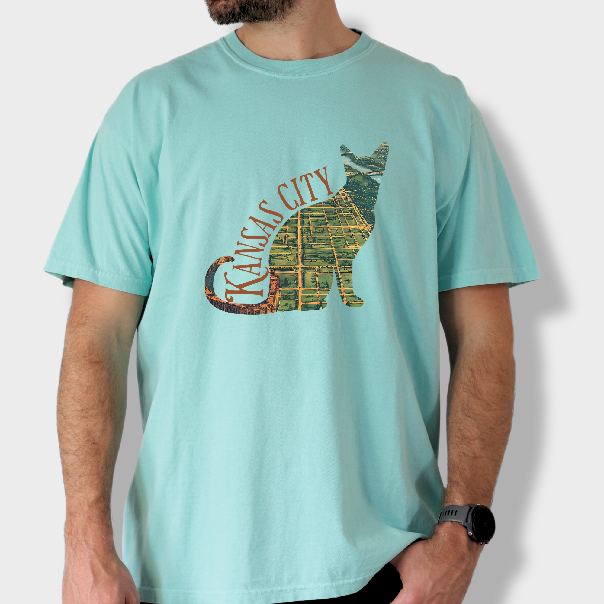 Artistic Kansas City-themed T-shirt with a satellite map of Missouri’s largest city bordered by a cat outline, perfect for cat lovers and city dwellers.