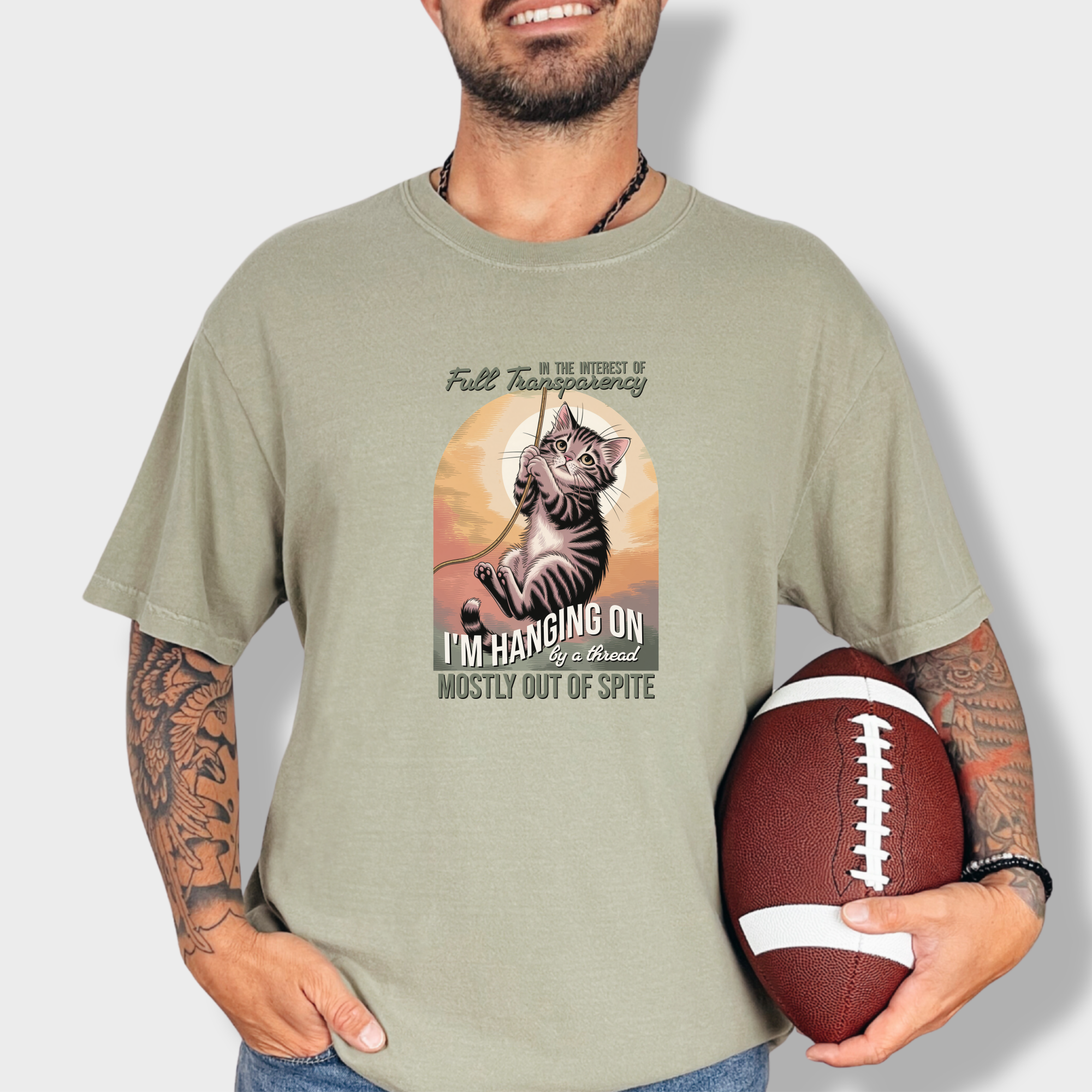 western-hanging-on-by-a-thread-cat-graphic-comfort-colors-t-shirt-in-khaki - Khaki Lifestyle Male Model
