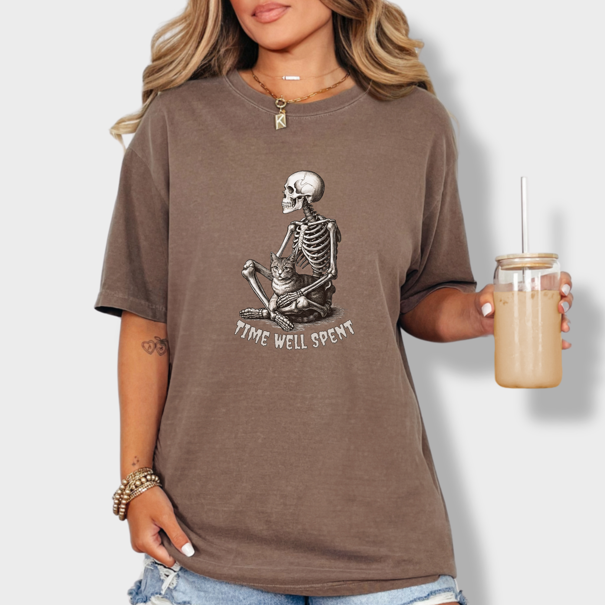line-art-sit-still-skeleton-petting-cat-cat-skeleton-comfort-colors-t-shirt-in-espresso - Espresso Lifestyle Female Model