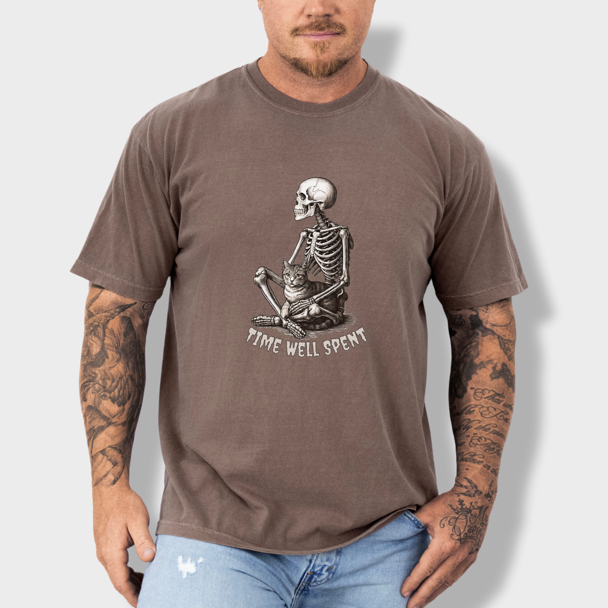 line-art-sit-still-skeleton-petting-cat-cat-skeleton-comfort-colors-t-shirt-in-espresso - Espresso Lifestyle Male Model