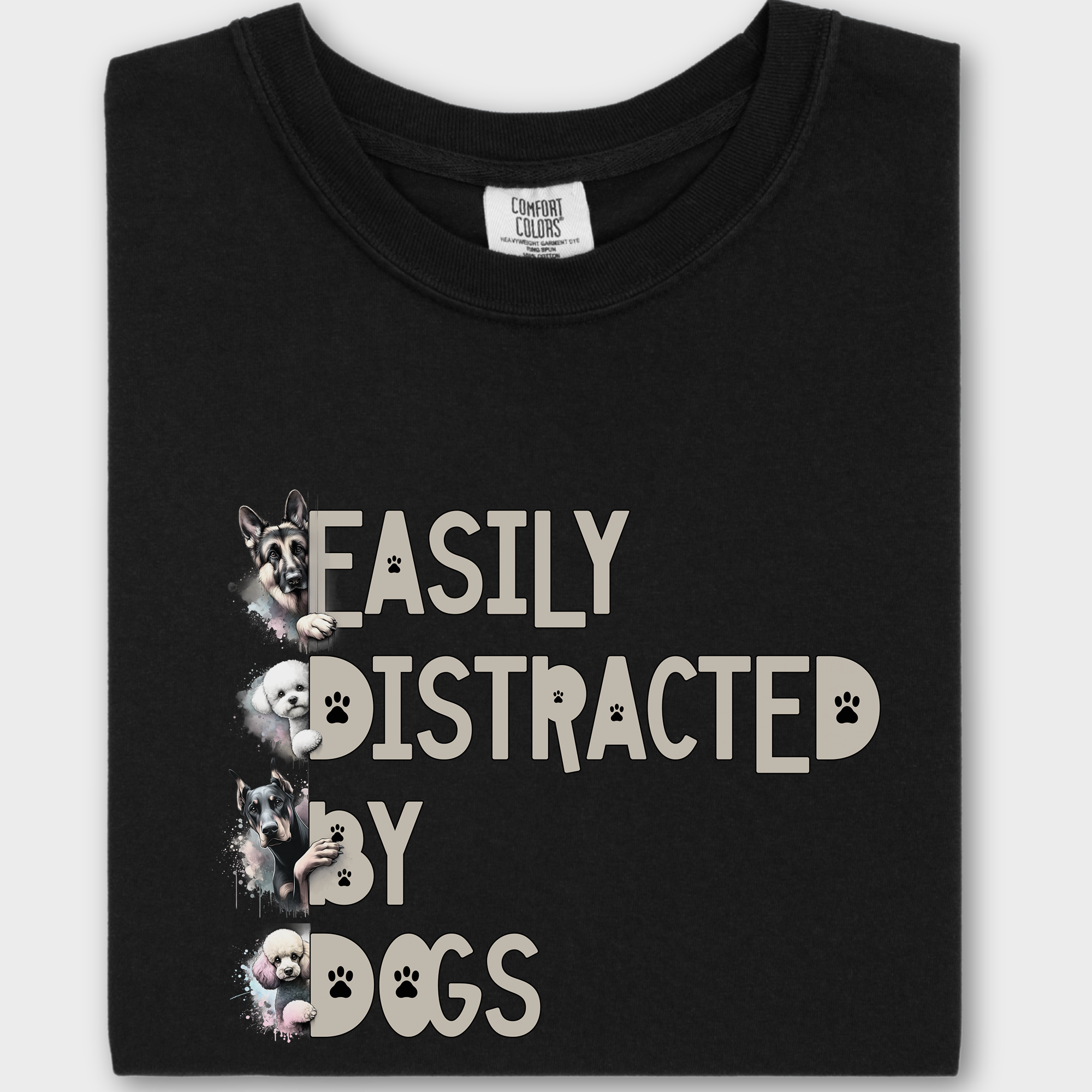 Colorful watercolor dog T-shirt featuring the phrase 'Easily Distracted by Dogs' with illustrations of a German Shepherd, Bichon Frise, Doberman, and Miniature Poodle.