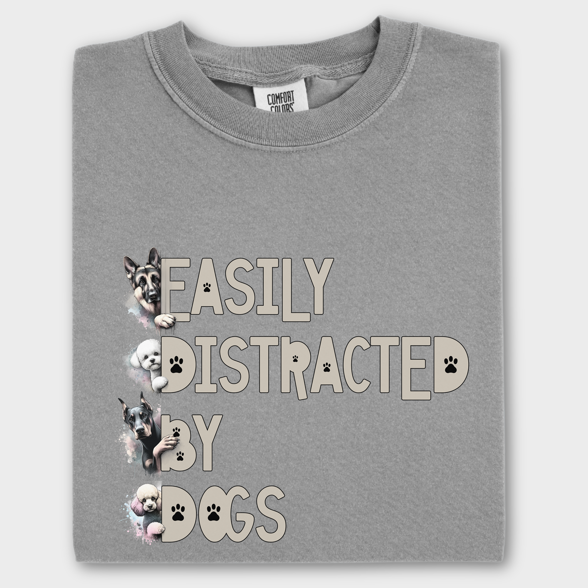 Colorful watercolor dog T-shirt featuring the phrase 'Easily Distracted by Dogs' with illustrations of a German Shepherd, Bichon Frise, Doberman, and Miniature Poodle.