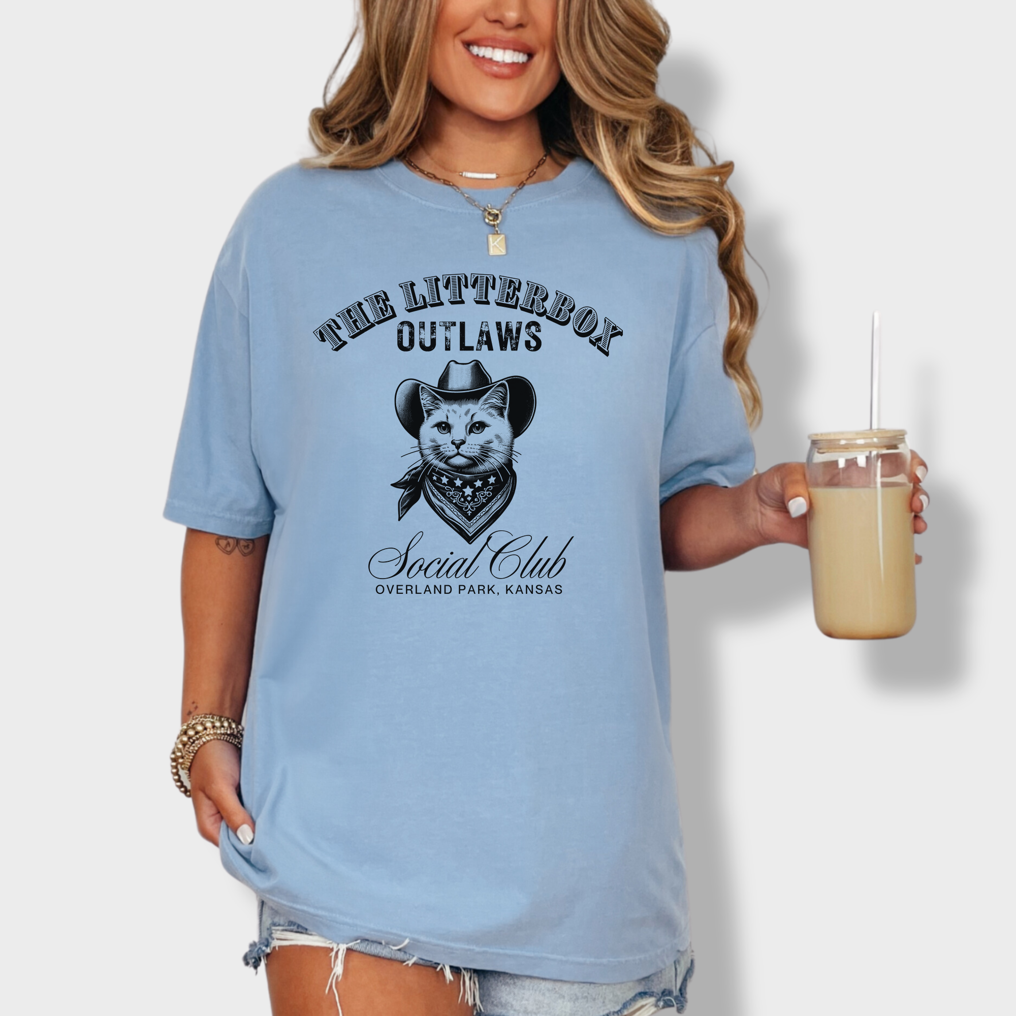 Soft cotton T-shirt featuring a rugged outlaw cat in a cowboy hat, part of the Litterbox Outlaws Social Club, with a personalized location.
