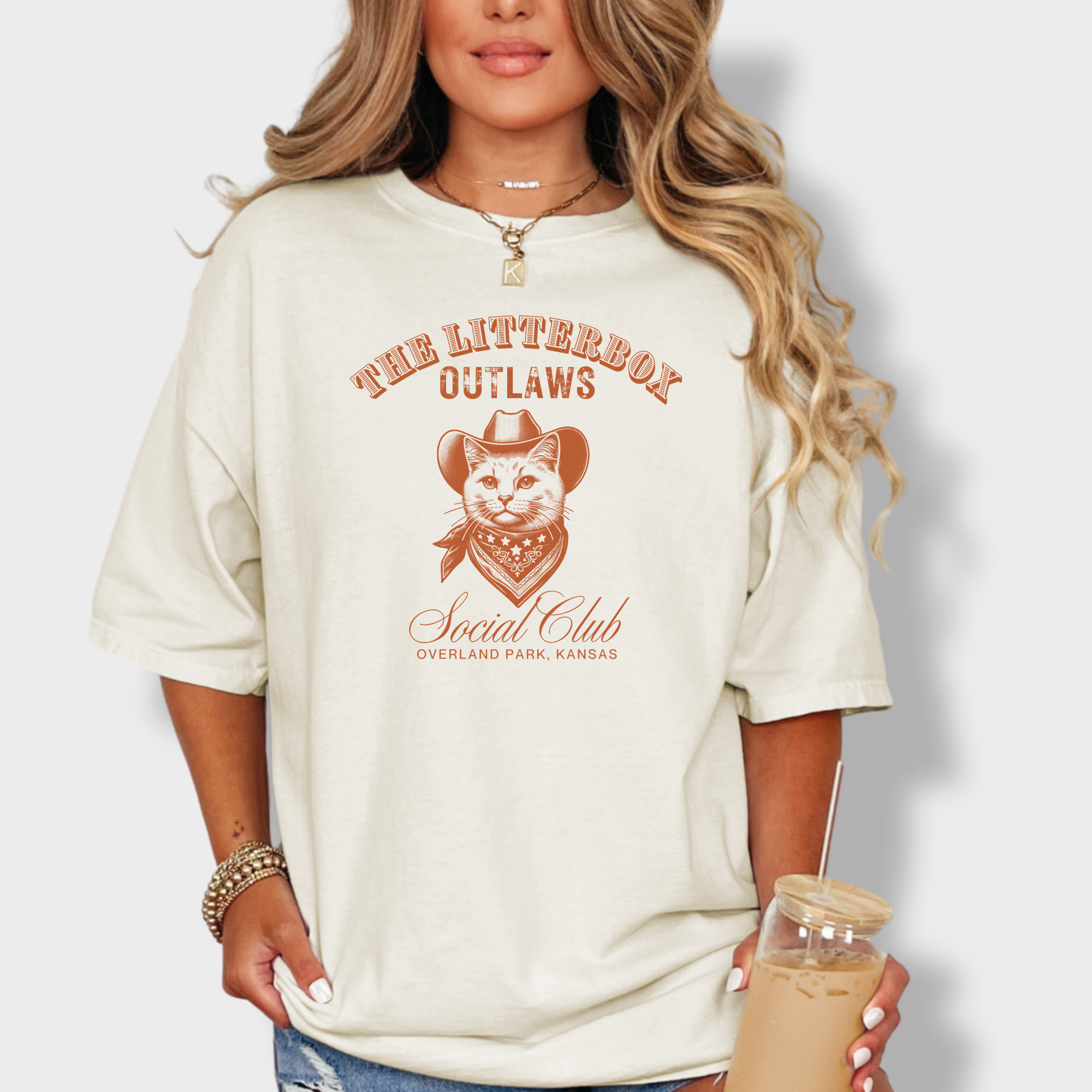 Soft cotton T-shirt featuring a rugged outlaw cat in a cowboy hat, part of the Litterbox Outlaws Social Club, with a personalized location.