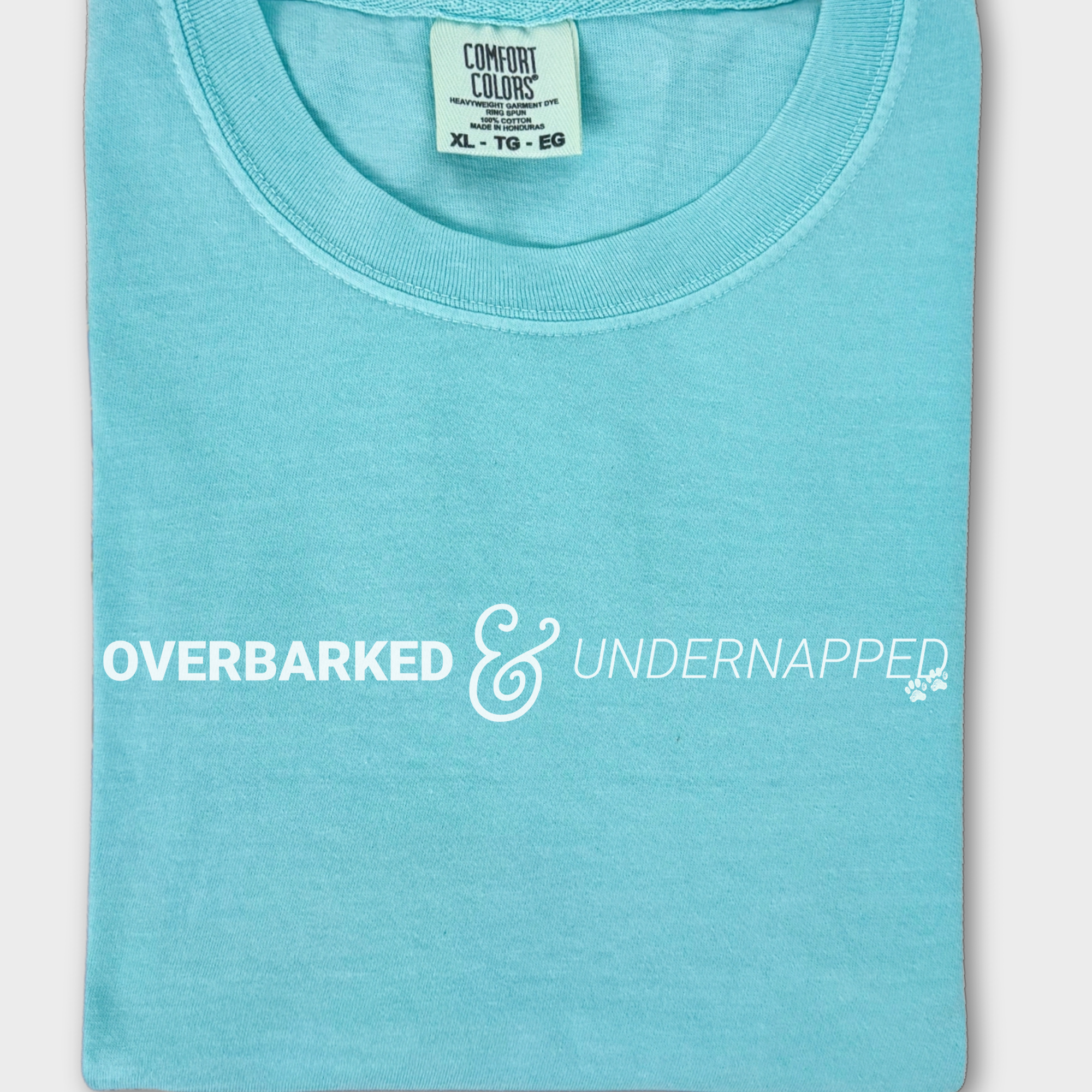 Funny dog lover’s T-shirt featuring the phrase 'Overbarked & Undernapped' with two paw prints, printed on soft cotton.
