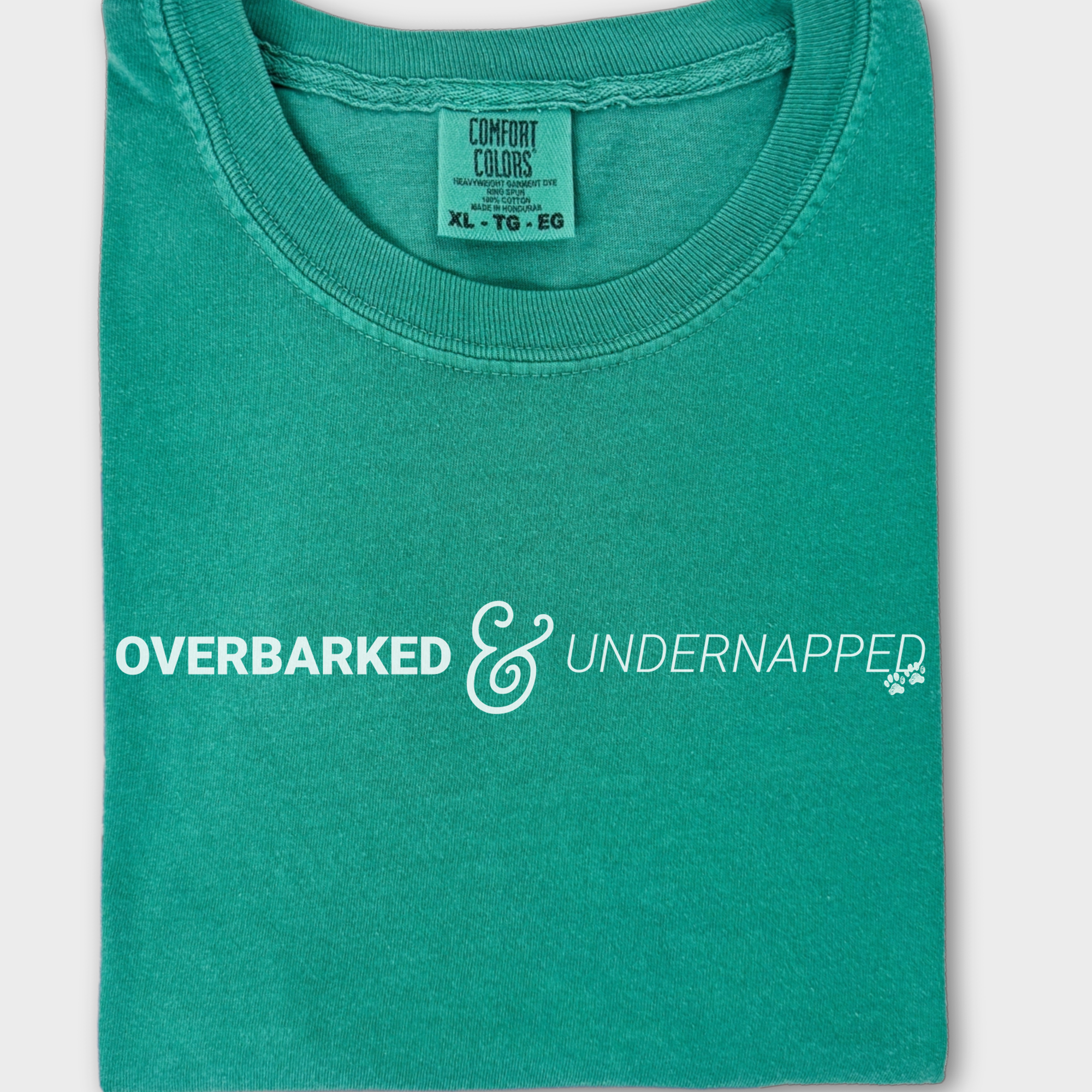 Funny dog lover’s T-shirt featuring the phrase 'Overbarked & Undernapped' with two paw prints, printed on soft cotton.