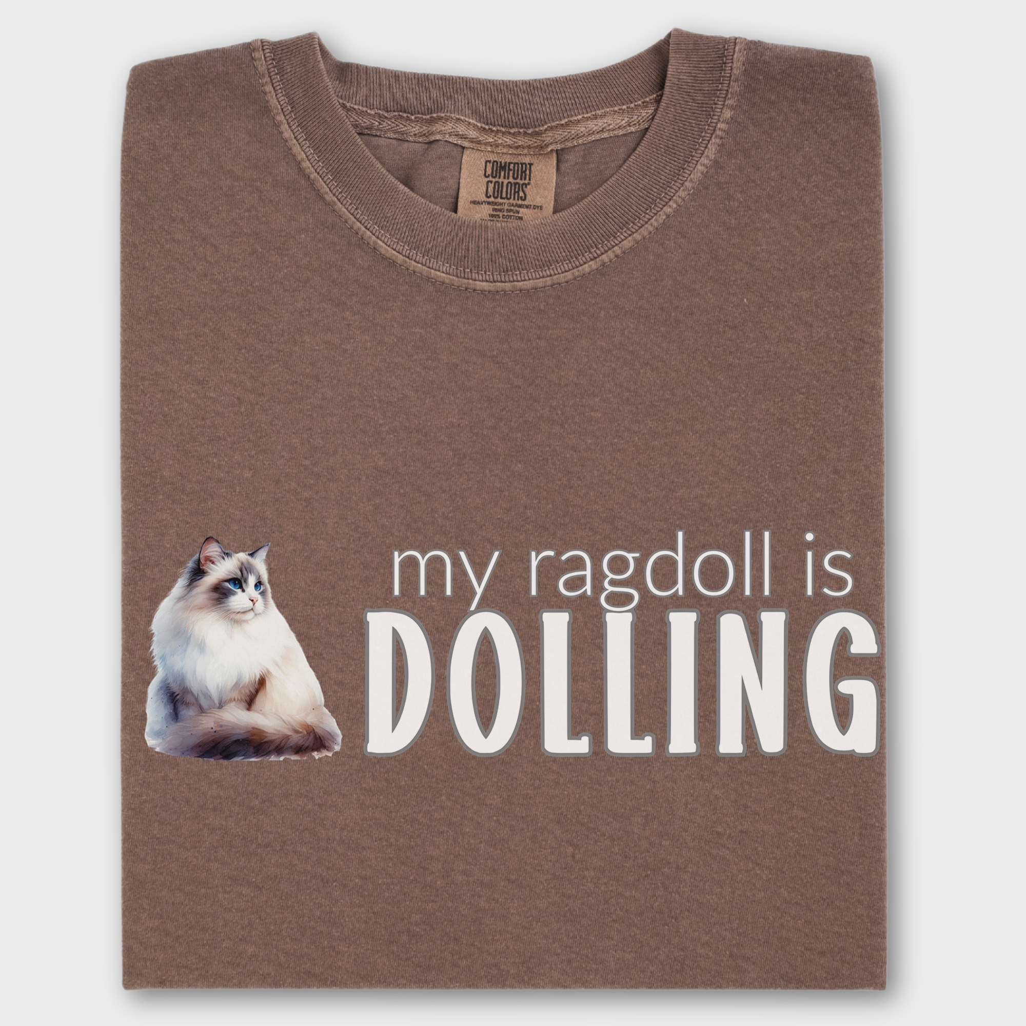 Watercolor Ragdoll cat T-shirt with the fun phrase 'My Ragdoll is Dolling,' printed on soft 100% cotton.