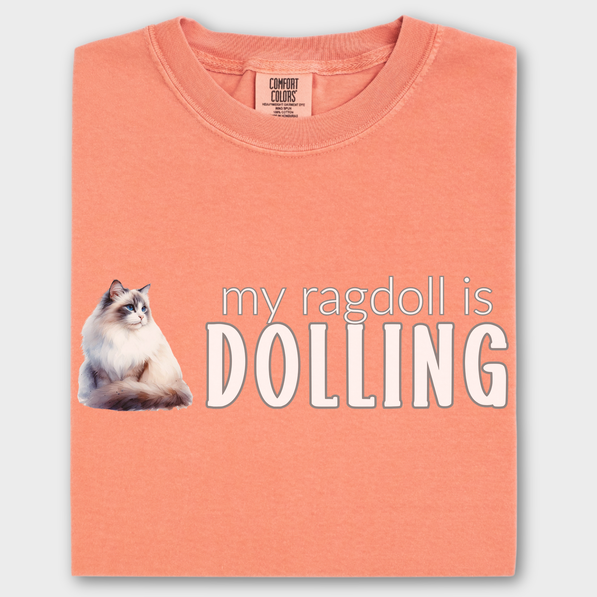 Watercolor Ragdoll cat T-shirt with the fun phrase 'My Ragdoll is Dolling,' printed on soft 100% cotton.