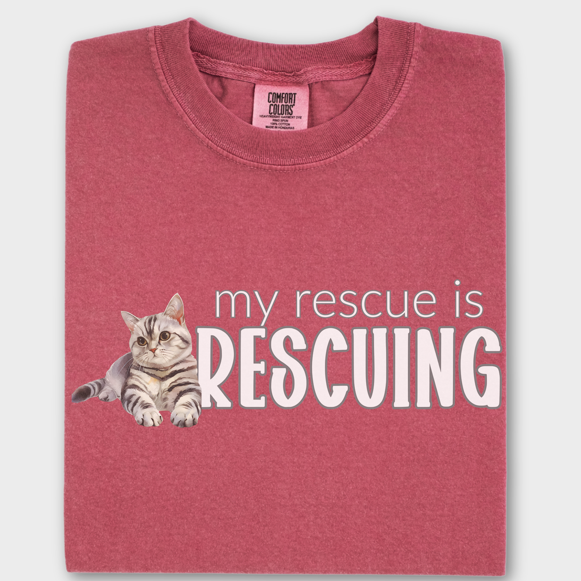 Watercolor rescue cat T-shirt with the heartfelt phrase 'My Rescue is Rescuing,' printed on soft 100% cotton.