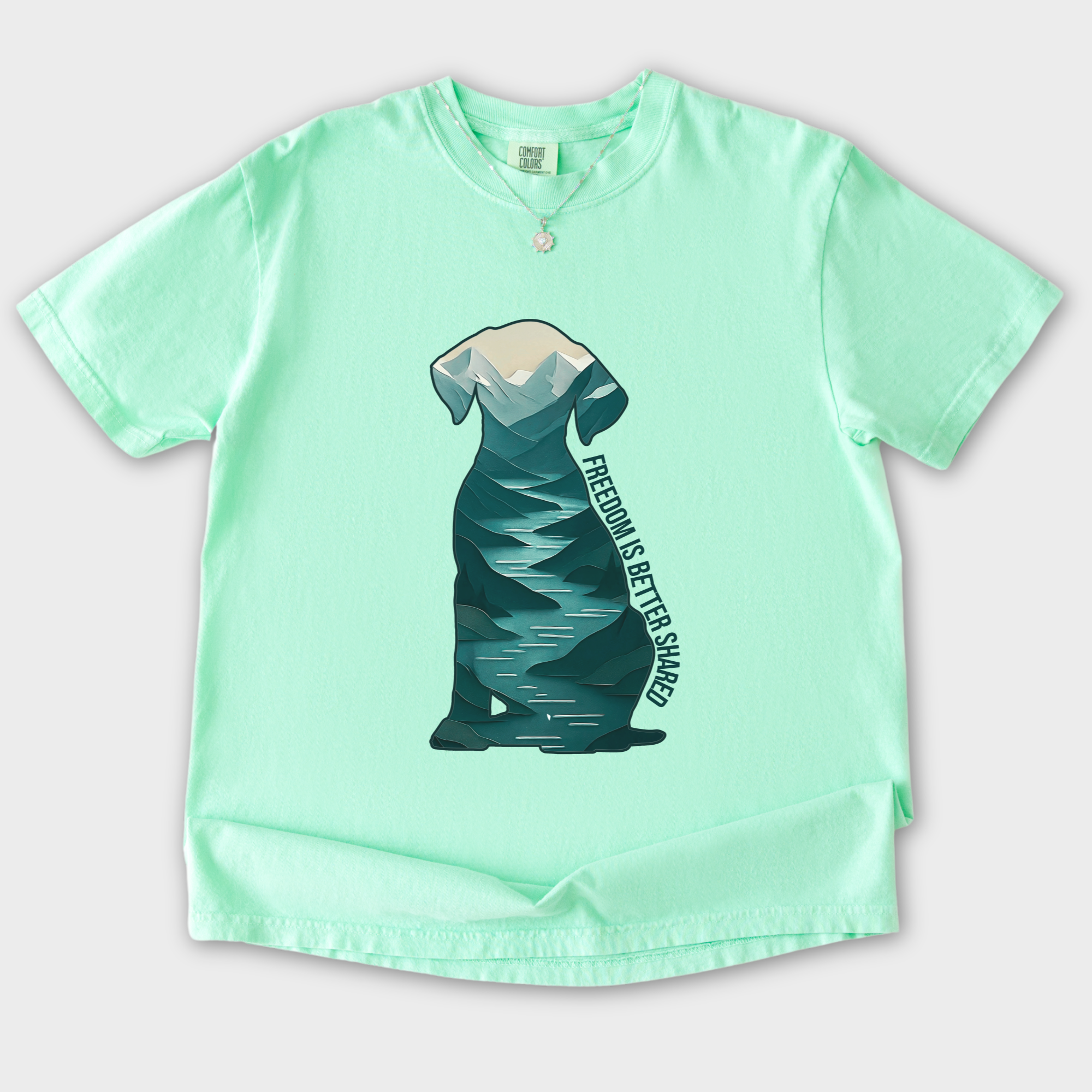 vintage-mountain-freedom-is-better-shared-dog-graphic-comfort-colors-t-shirt-in-island-reef - Island Reef Flat Lay Front