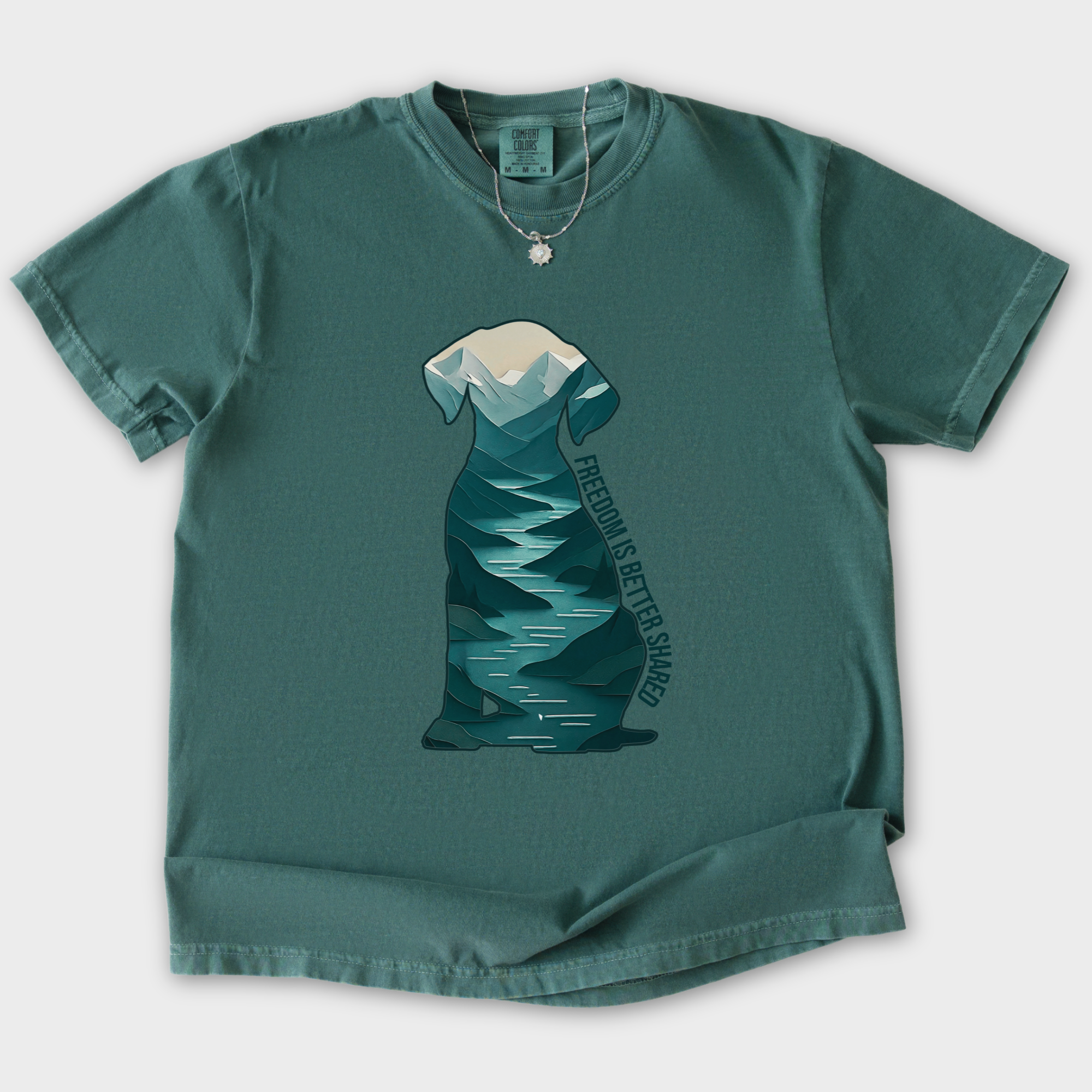vintage-mountain-freedom-is-better-shared-dog-graphic-comfort-colors-t-shirt-in-blue-spruce - Blue Spruce Flat Lay Front