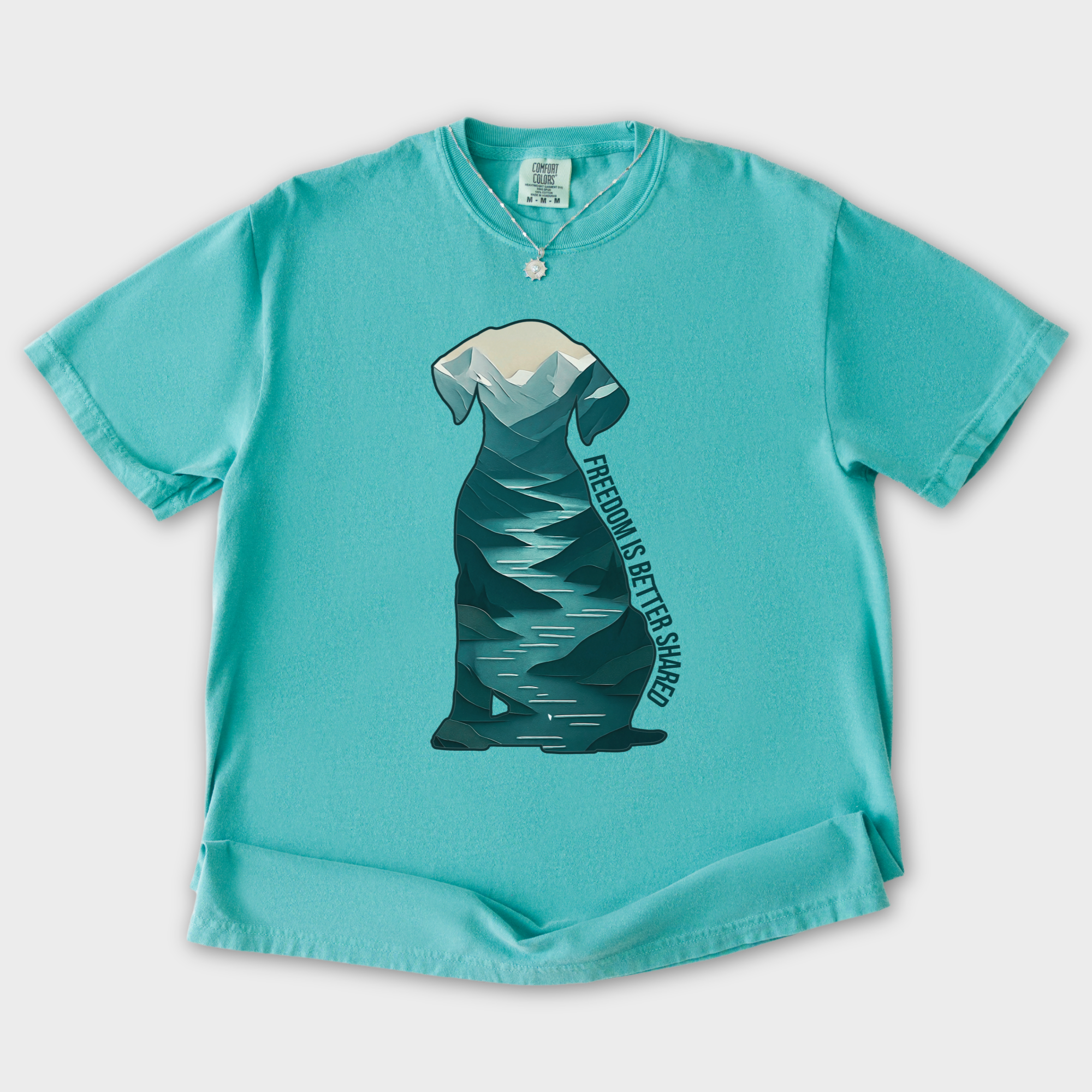 vintage-mountain-freedom-is-better-shared-dog-graphic-comfort-colors-t-shirt-in-seafoam - Seafoam Flat Lay Front