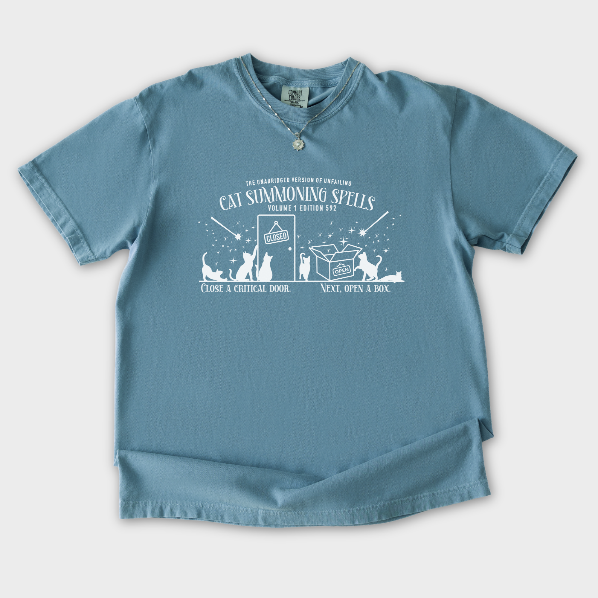 cat-summoning-spells-t-shirt-in-ice-blue - Ice Blue Flat Lay Front