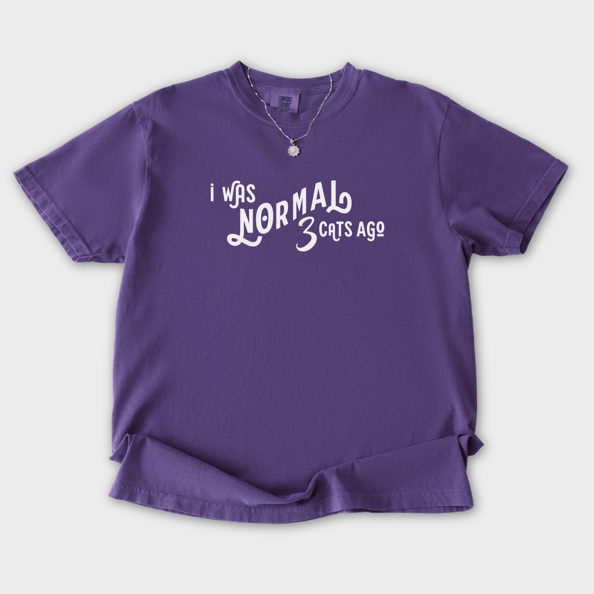 Comfort Colors® Cat unisex tee for men and women featuring Minimalist, I Was Normal 3 Cats Ago Grape graphic T-Shirt made of 100% cotton by Fetch N Found - Grape Flat Lay Front