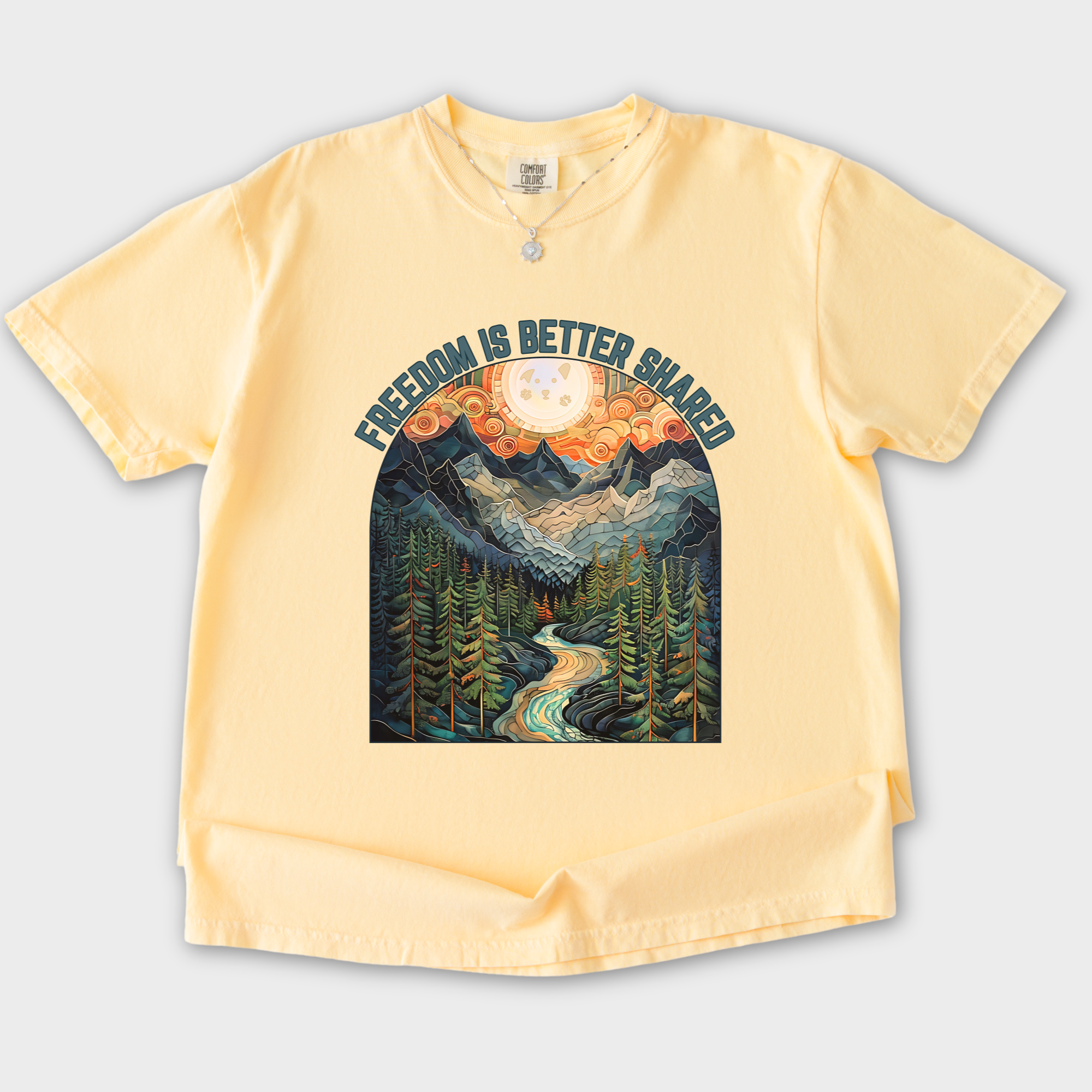 artistic-mountain-freedom-is-better-shared-stained-glass-version-dog-graphic-comfort-colors-t-shirt-in-butter - Butter Flat Lay Front