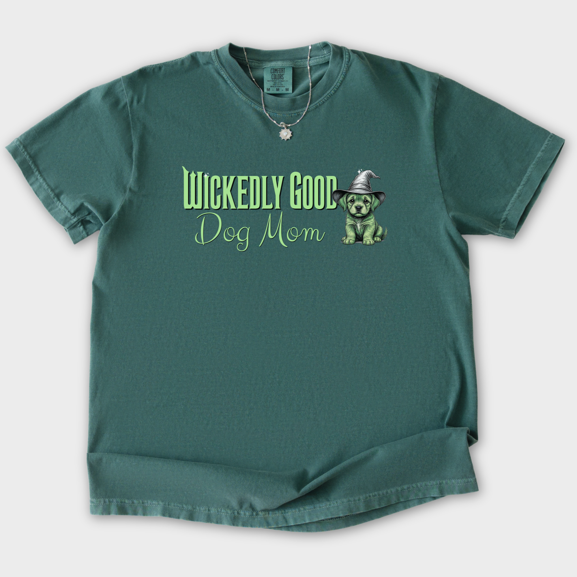 movie-inspired-green-wickedly-good-dog-mom-dog-graphic-comfort-colors-t-shirt-in-blue-spruce - Blue Spruce Flat Lay Front