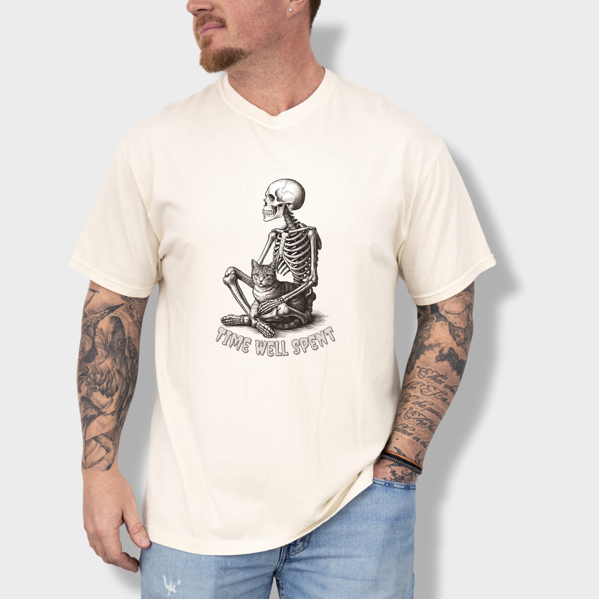 line-art-sit-still-skeleton-petting-cat-cat-skeleton-comfort-colors-t-shirt-in-ivory - Ivory Lifestyle Male Model