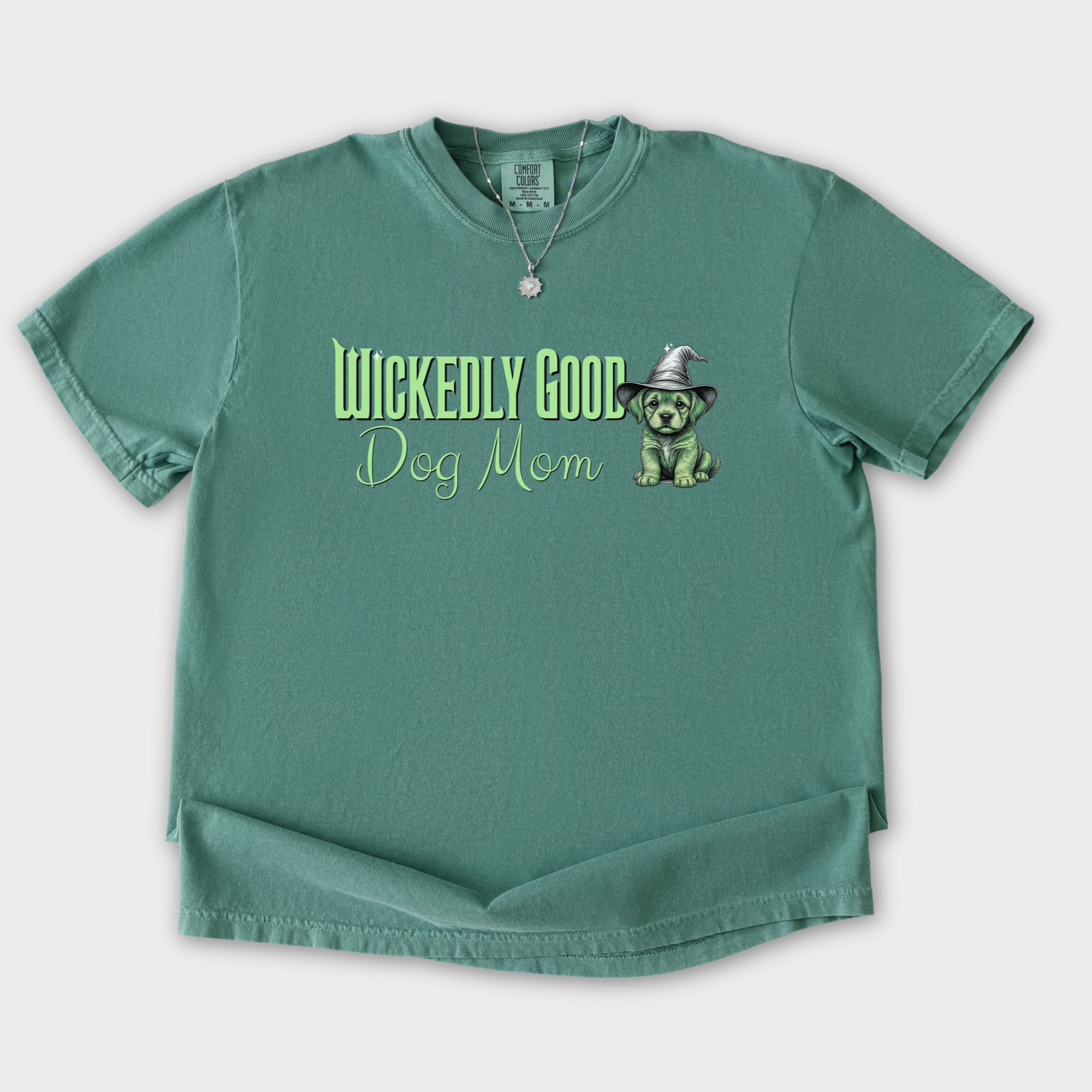 movie-inspired-green-wickedly-good-dog-mom-dog-graphic-comfort-colors-t-shirt-in-light-green - Light Green Flat Lay Front