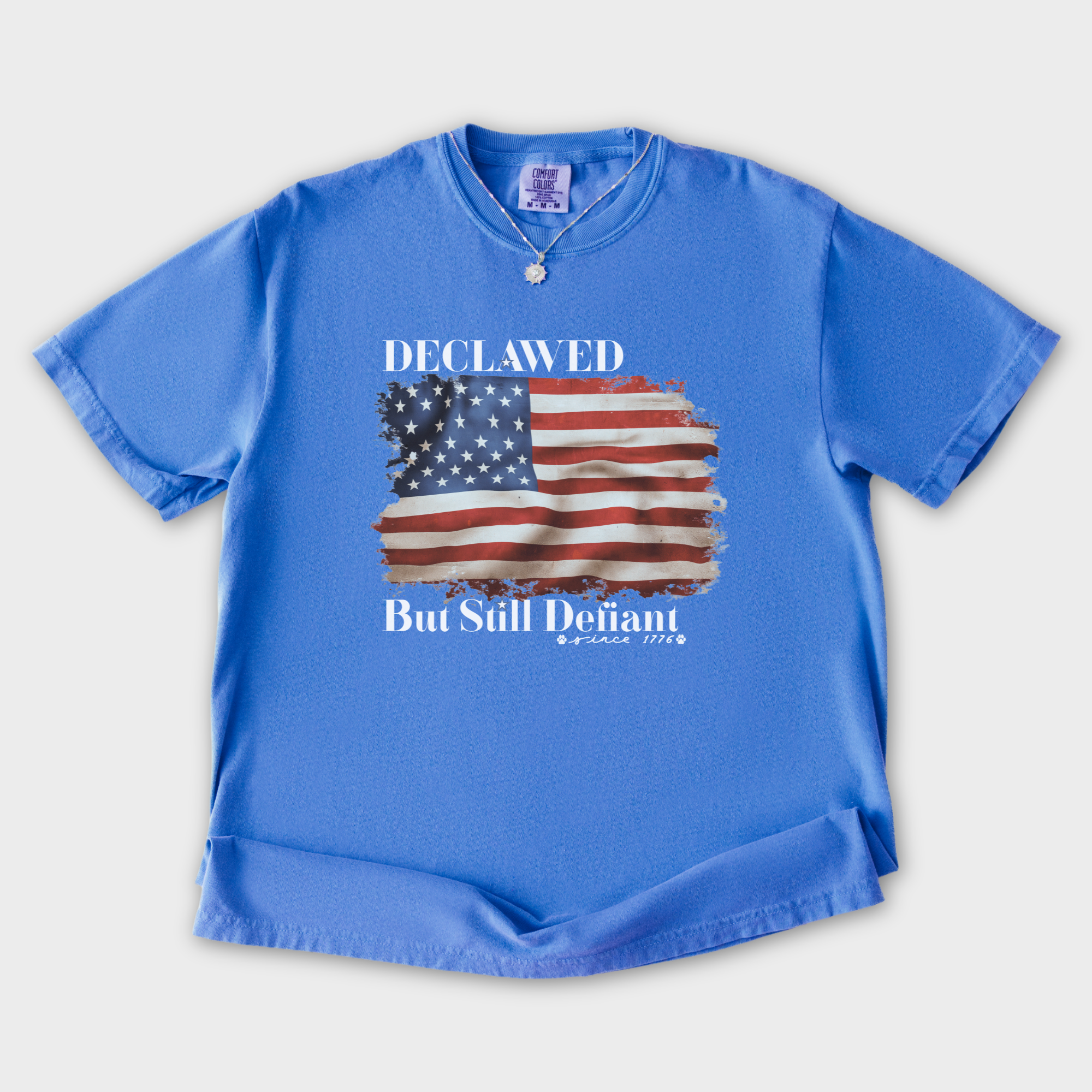 vintage-declawed-but-still-defiant-fourth-of-july-united-states-flag-cat-graphic-comfort-colors-t-shirt-in-flo-blue - Flo Blue Flat Lay Front