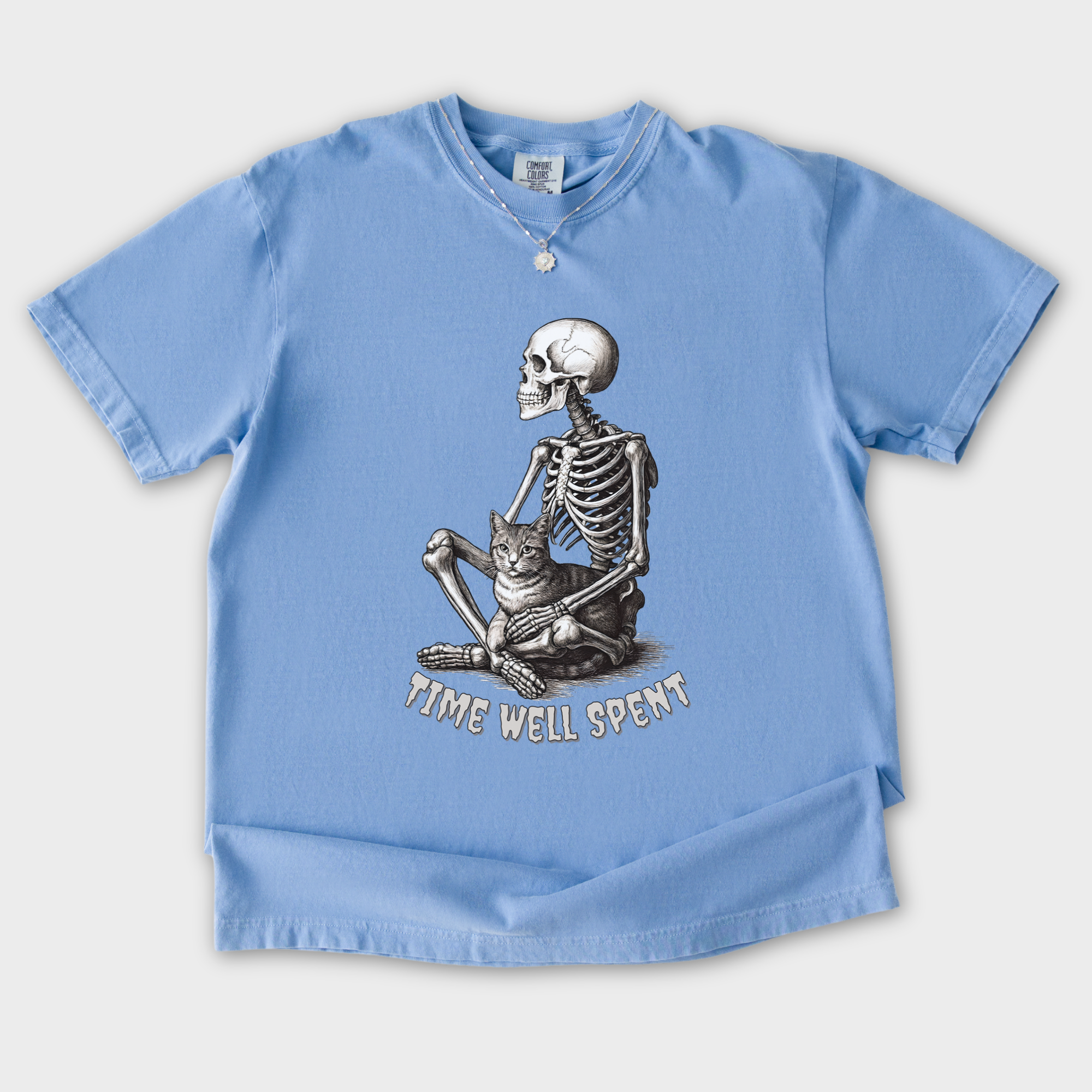 line-art-sit-still-skeleton-petting-cat-cat-skeleton-comfort-colors-t-shirt-in-washed-denim - Washed Denim Flat Lay Front