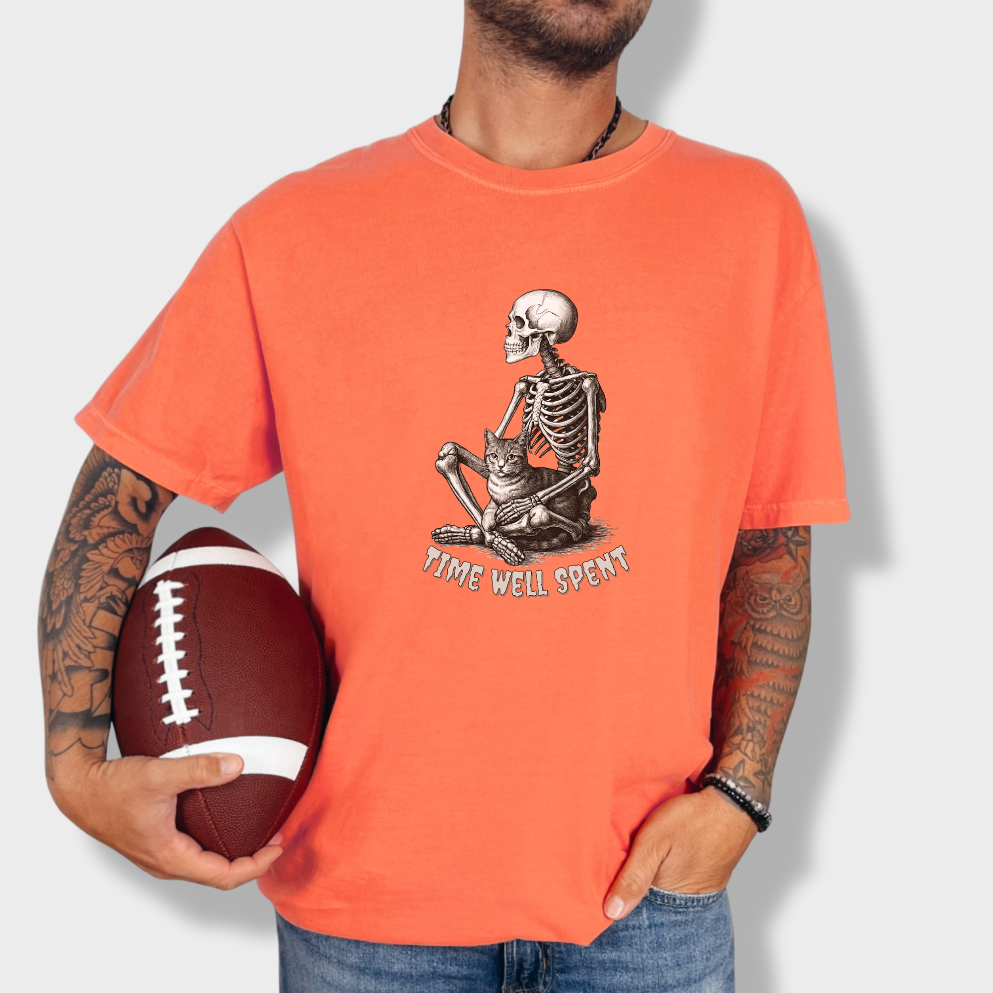 line-art-sit-still-skeleton-petting-cat-cat-skeleton-comfort-colors-t-shirt-in-bright-salmon - Bright Salmon Lifestyle Male Model