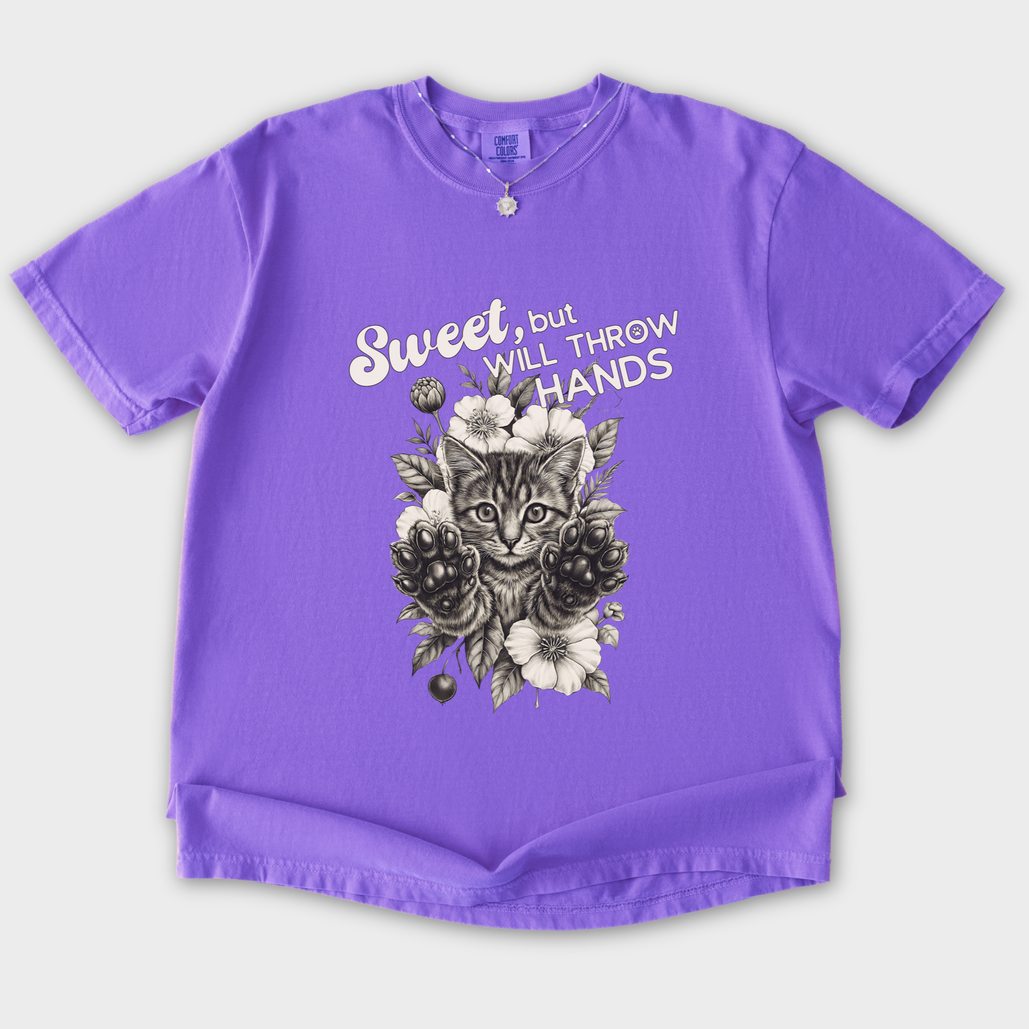 minimalist-sweet-but-will-throw-hands-cat-text-comfort-colors-t-shirt-in-violet - Violet Flat Lay Front