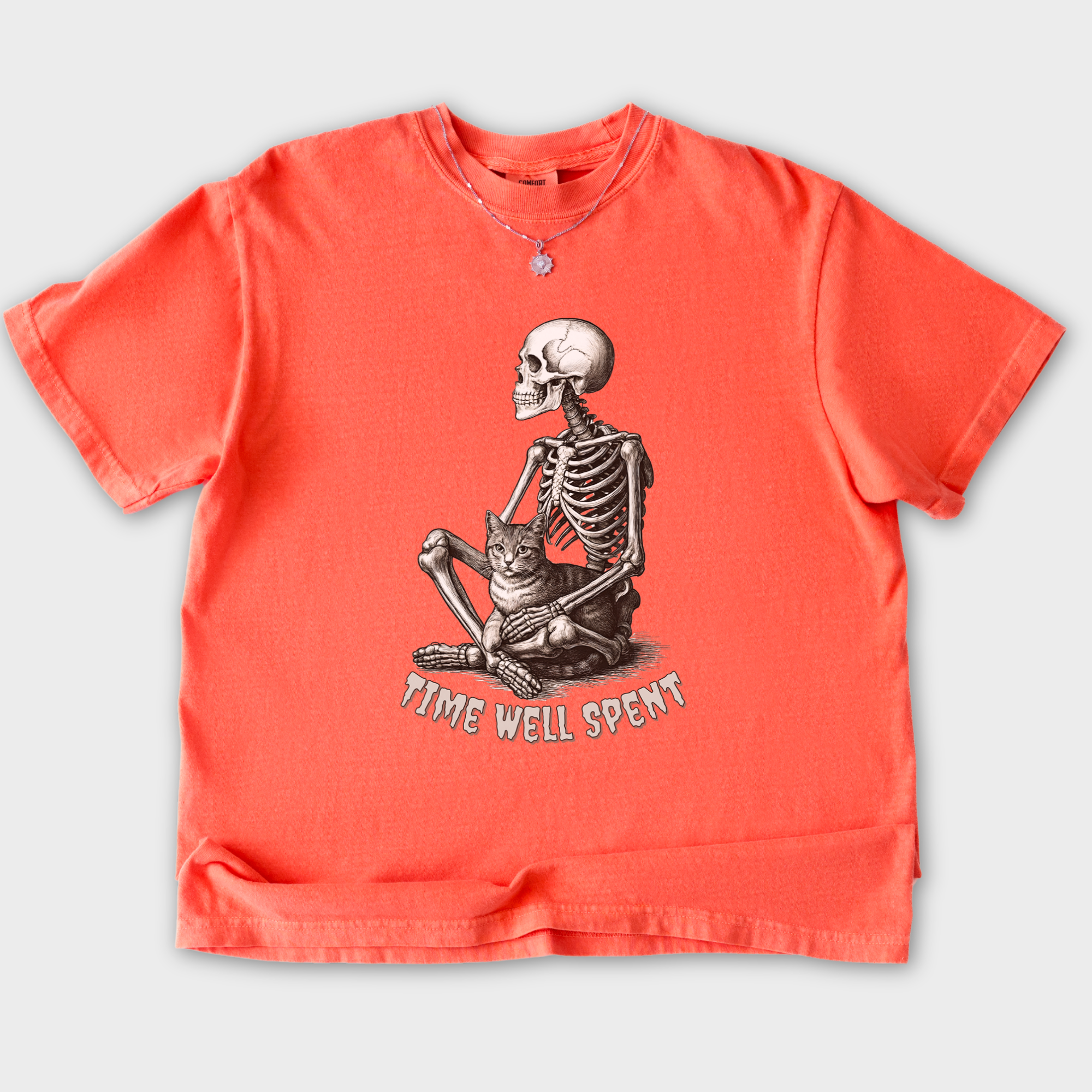 line-art-sit-still-skeleton-petting-cat-cat-skeleton-comfort-colors-t-shirt-in-bright-salmon - Bright Salmon Flat Lay Front