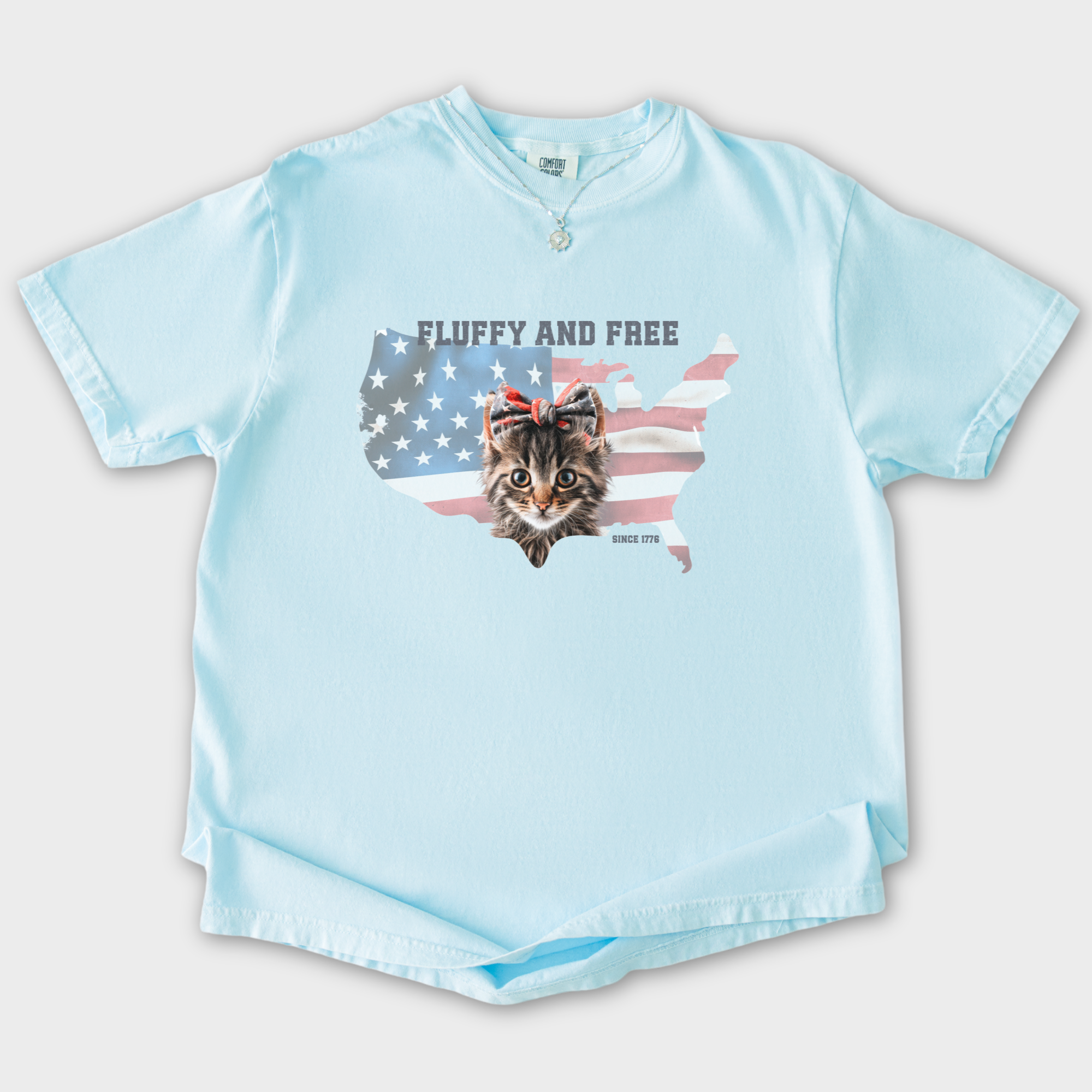 retro-fluffy-and-free-fourth-of-july-kitty-cat-graphic-comfort-colors-t-shirt-in-chambray - Chambray Flat Lay Front