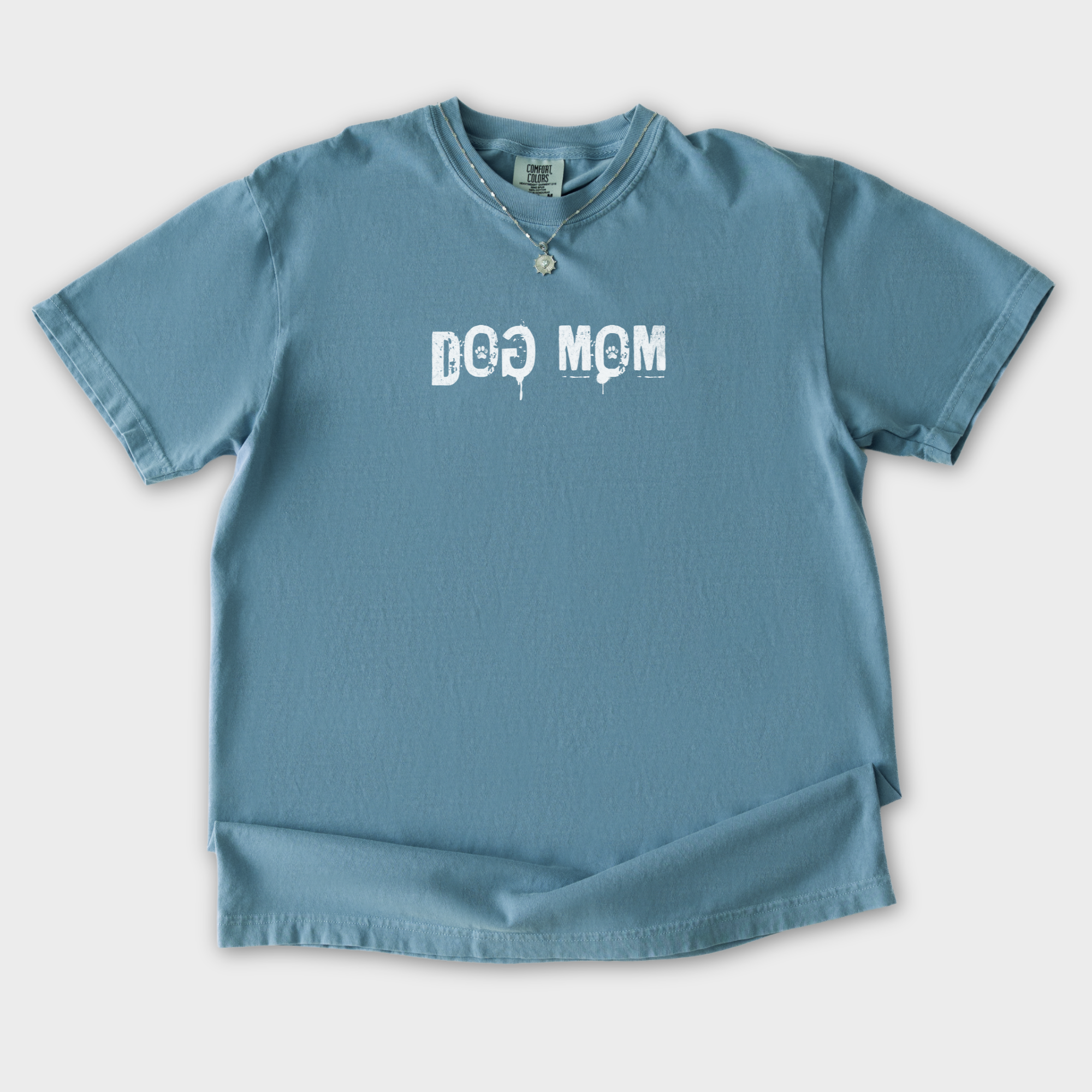minimalist-dog-mom-messy-stamp-with-paint-splatter-dog-text-comfort-colors-t-shirt-in-ice-blue - Ice Blue Flat Lay Front