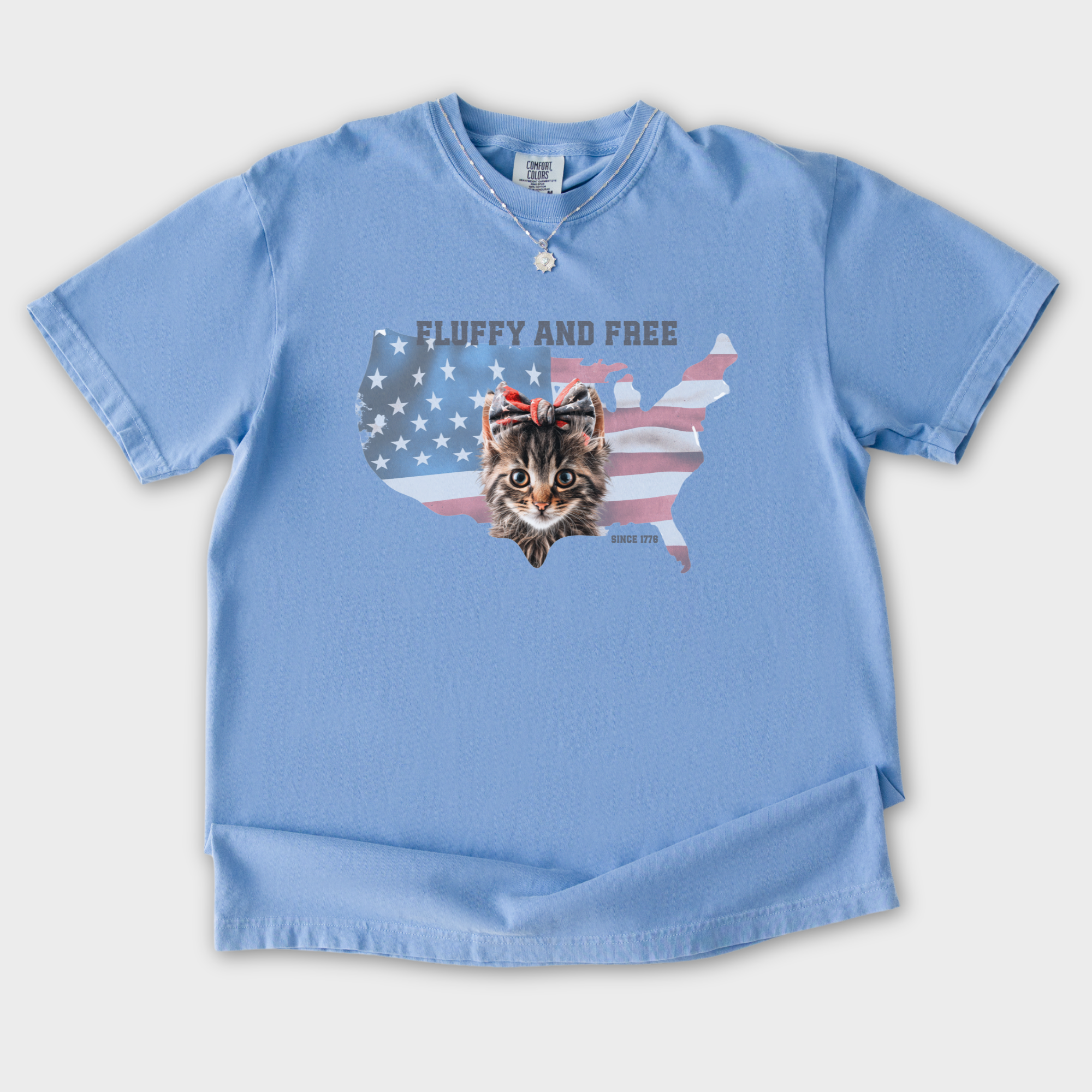 retro-fluffy-and-free-fourth-of-july-kitty-cat-graphic-comfort-colors-t-shirt-in-washed-denim - Washed Denim Flat Lay Front