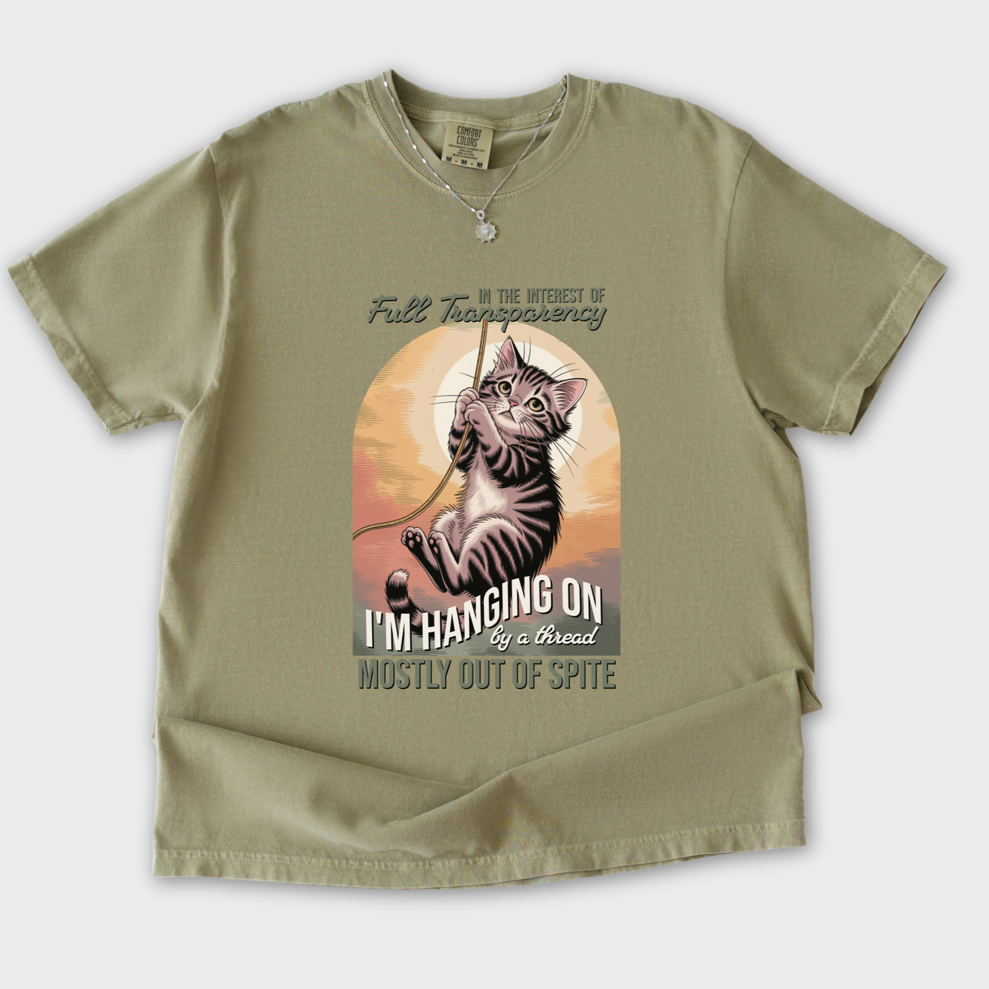western-hanging-on-by-a-thread-cat-graphic-comfort-colors-t-shirt-in-khaki - Khaki Flat Lay Front